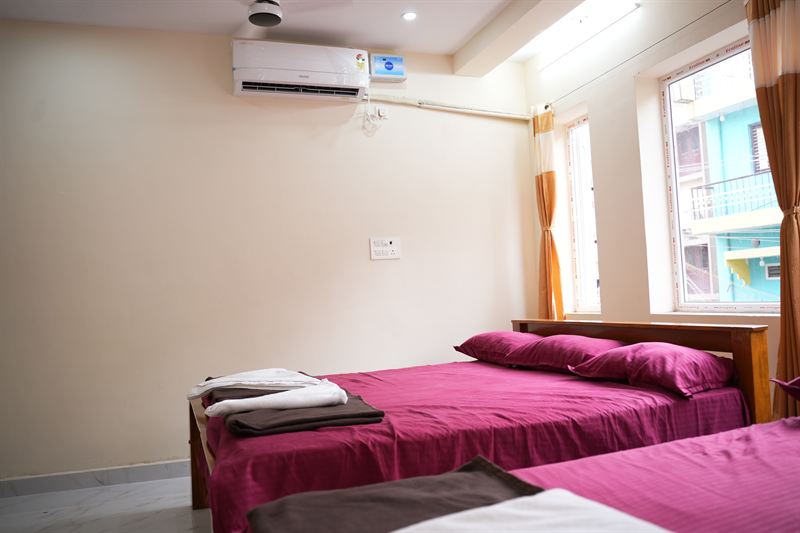 Wall-mounted AC unit beside an orange-curtained window