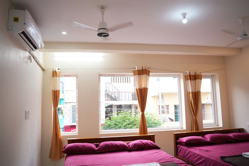 Bright family room looking toward three orange-curtained windows